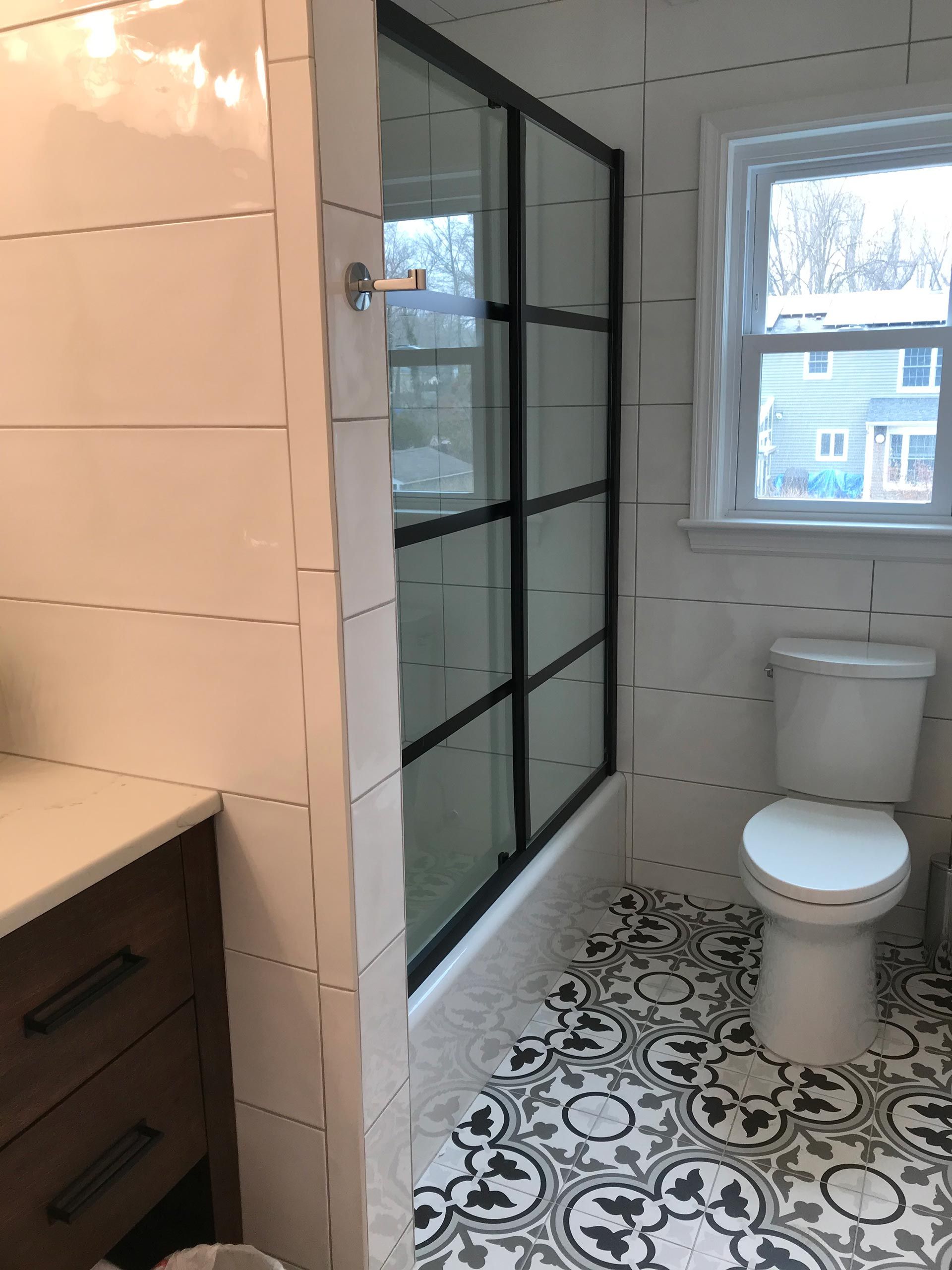A bathroom with a toilet and a shower stall
