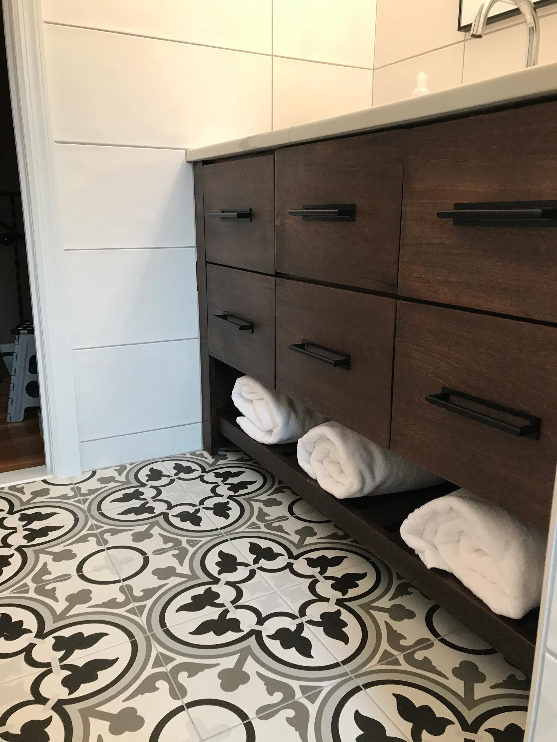 A bathroom with a sink and drawers filled with towels.