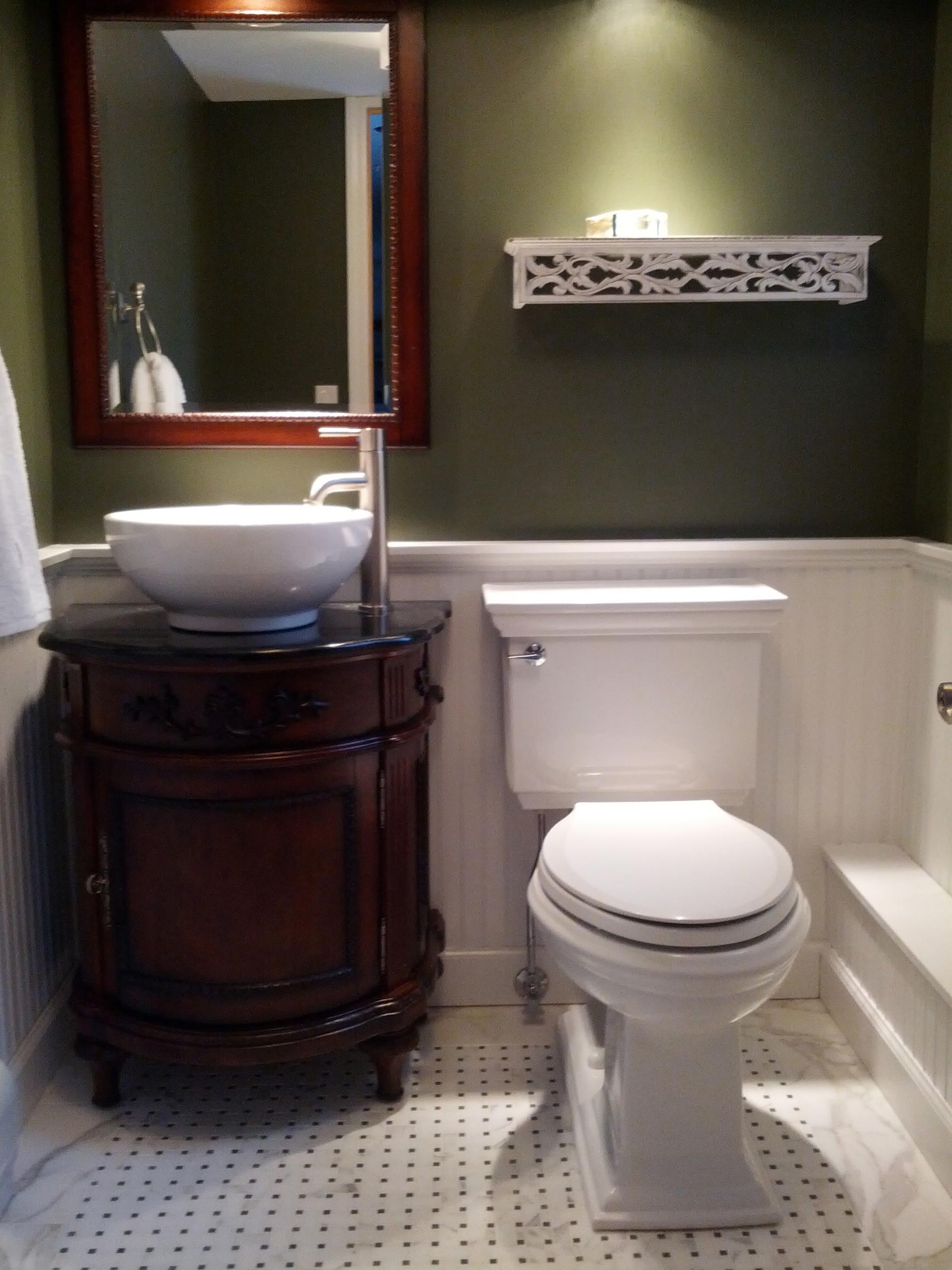 A bathroom with a toilet a sink and a mirror