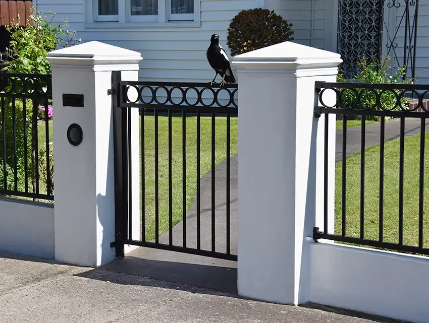 A Black Metal Front Gate With Magpie Sitting On It — Waratah Home Improvements in Coledale, NSW