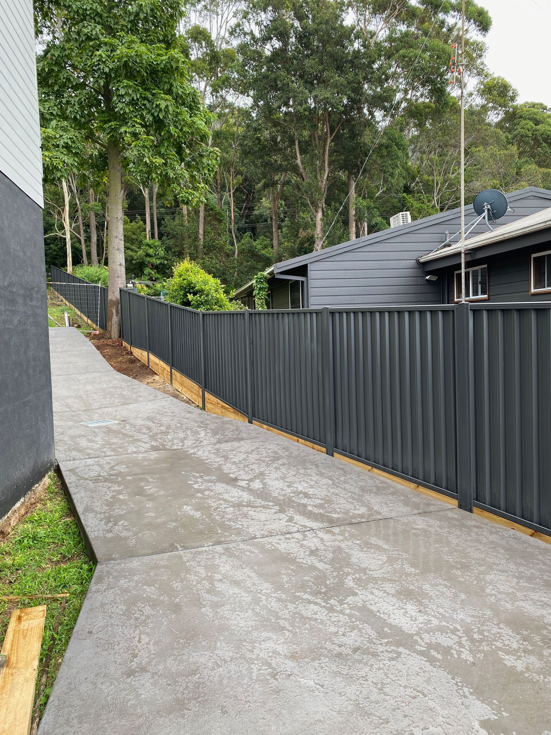 A Green Colorbond Fence On A Brick Foundation — Waratah Home Improvements in Coledale, NSW