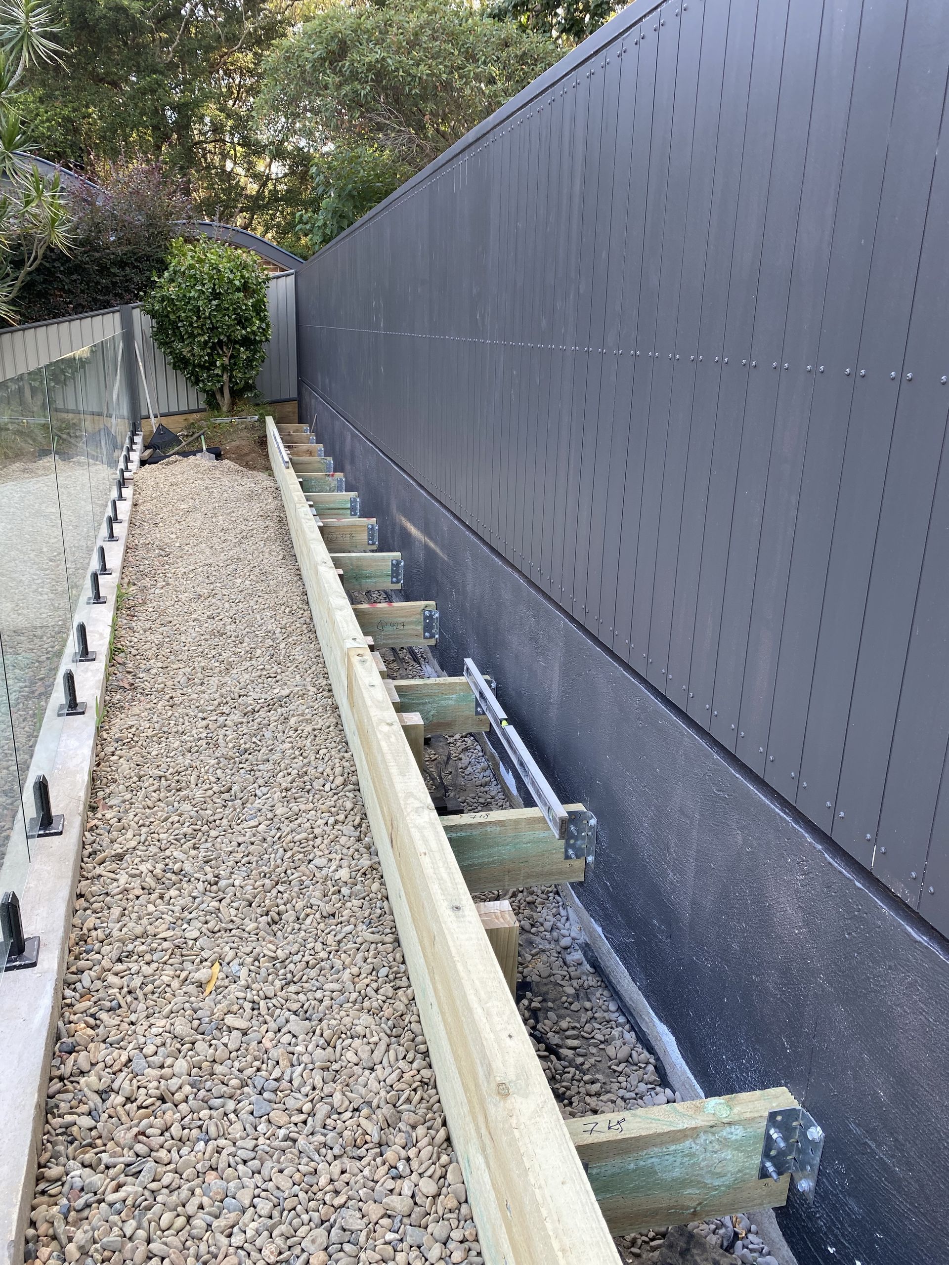 A Dark Grey Colorbond Fence Surrounding A Grassed Backyard — Waratah Home Improvements in Coledale, NSW