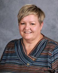 A woman in a striped shirt is smiling for a picture.