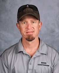 A man wearing a hat and sunglasses is posing for a picture.