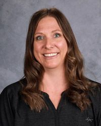A woman in a black shirt is smiling for the camera.