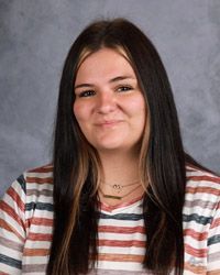A woman in a striped shirt is smiling for the camera.