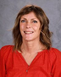 A woman wearing a black shirt is smiling for the camera.