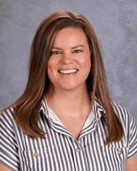 A woman red shirt is smiling for the camera.