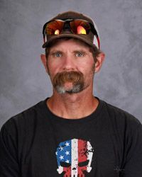 A man with a mustache is wearing a hat and sunglasses.