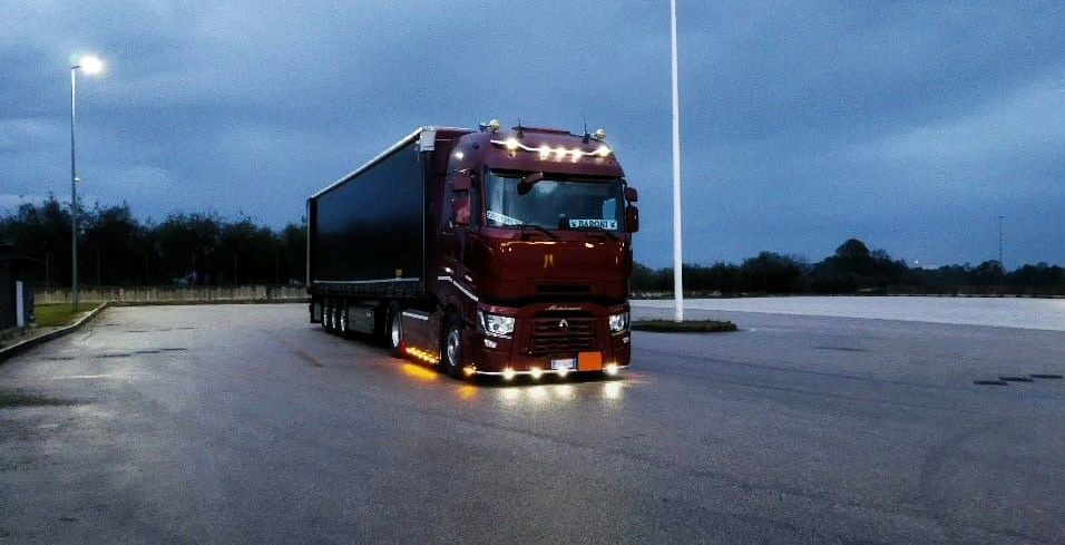 Autoarticolato con fiancata nera, parcheggiato all'aperto.