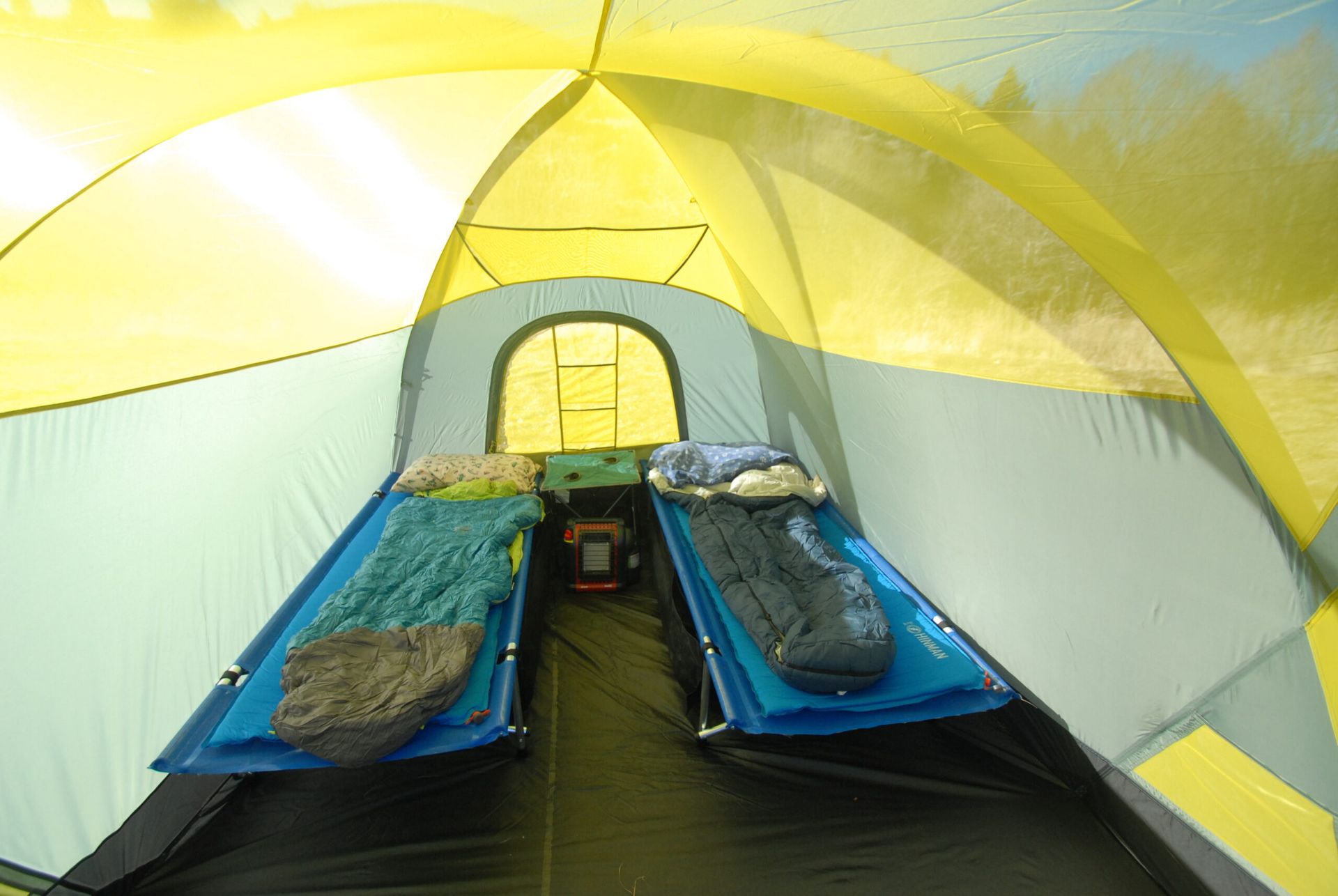 The inside of a tent with two beds and two sleeping bags