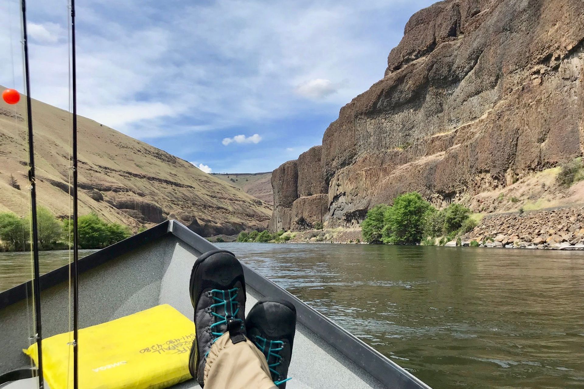 A person is sitting in a boat on a river.