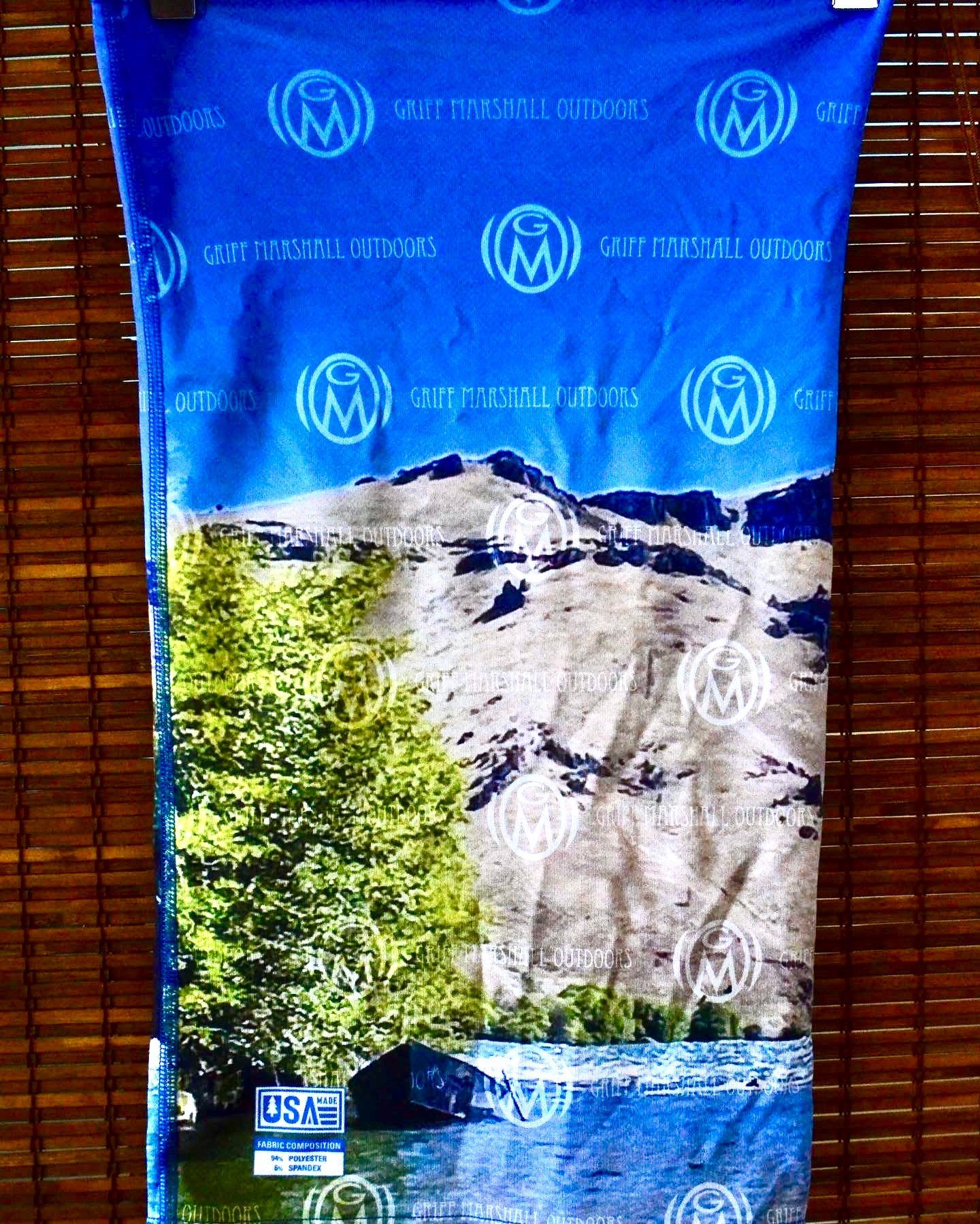 A blue bandana with mountains and trees on it