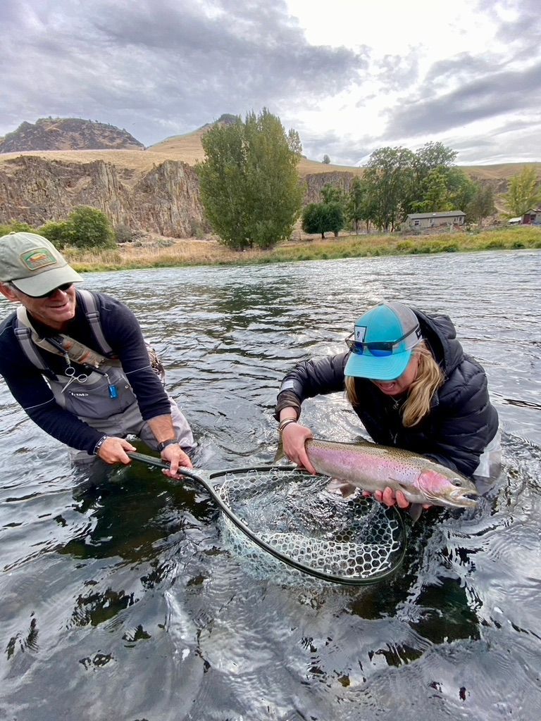 A man and a woman are fishing in a river.