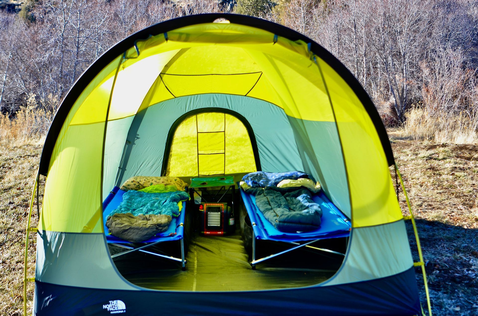 A yellow tent with two beds inside of it