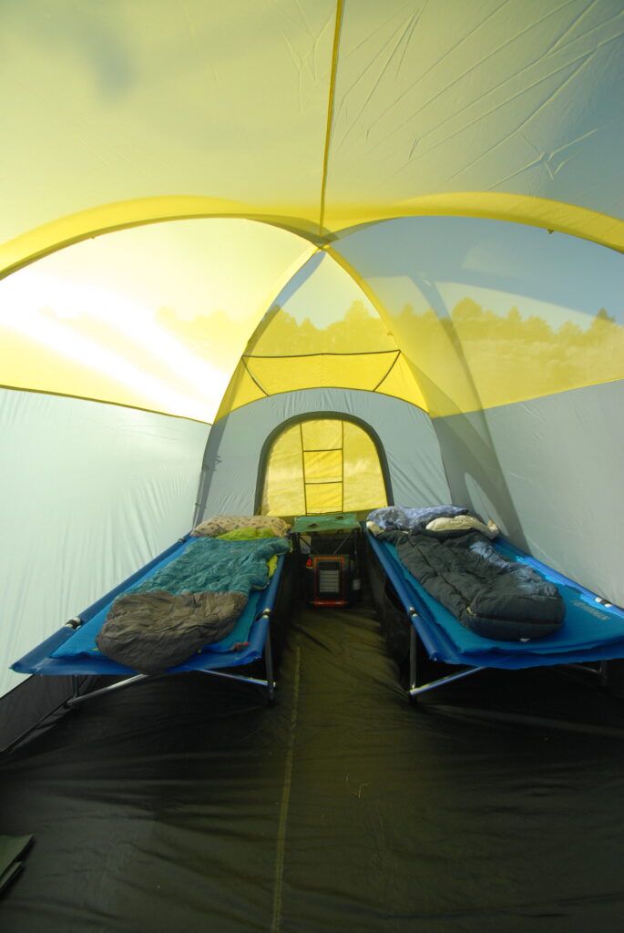 The inside of a tent with two beds and sleeping bags