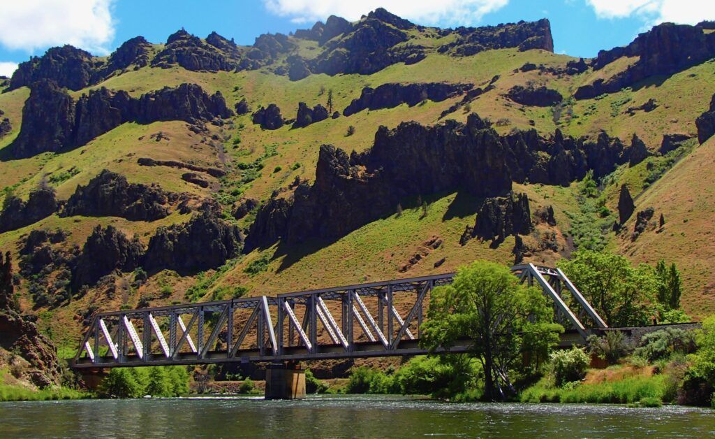 A bridge over a river with mountains in the background