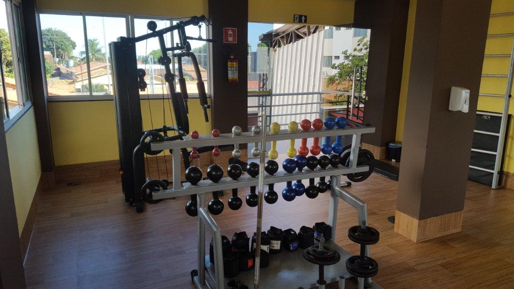 Uma academia com muitos halteres e um espelho