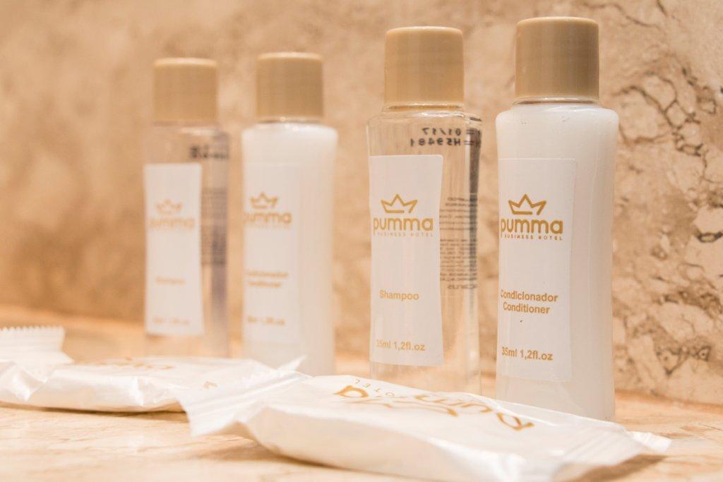 Um banheiro com frascos de xampu, loção e escovas de dente.