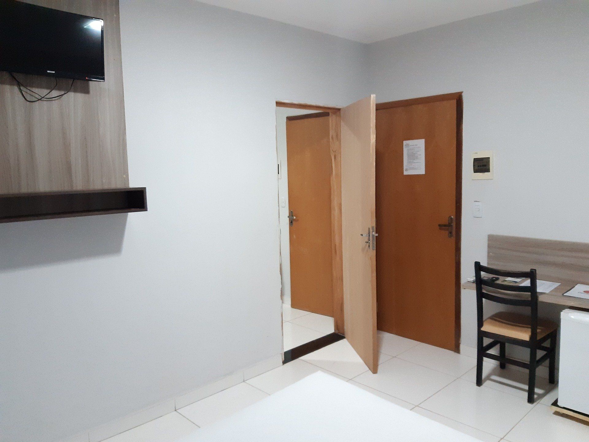 Um quarto de hotel com uma cama, uma escrivaninha e uma televisão