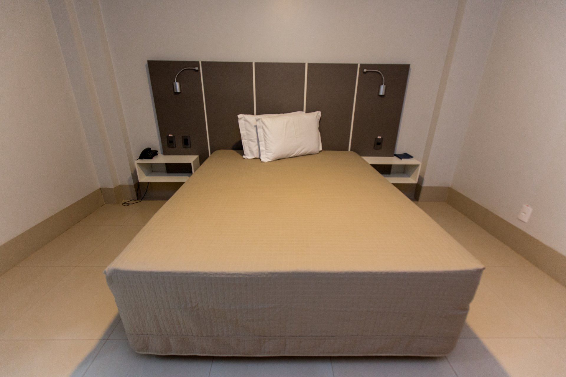 Um quarto de hotel com uma cama e duas mesas de cabeceira