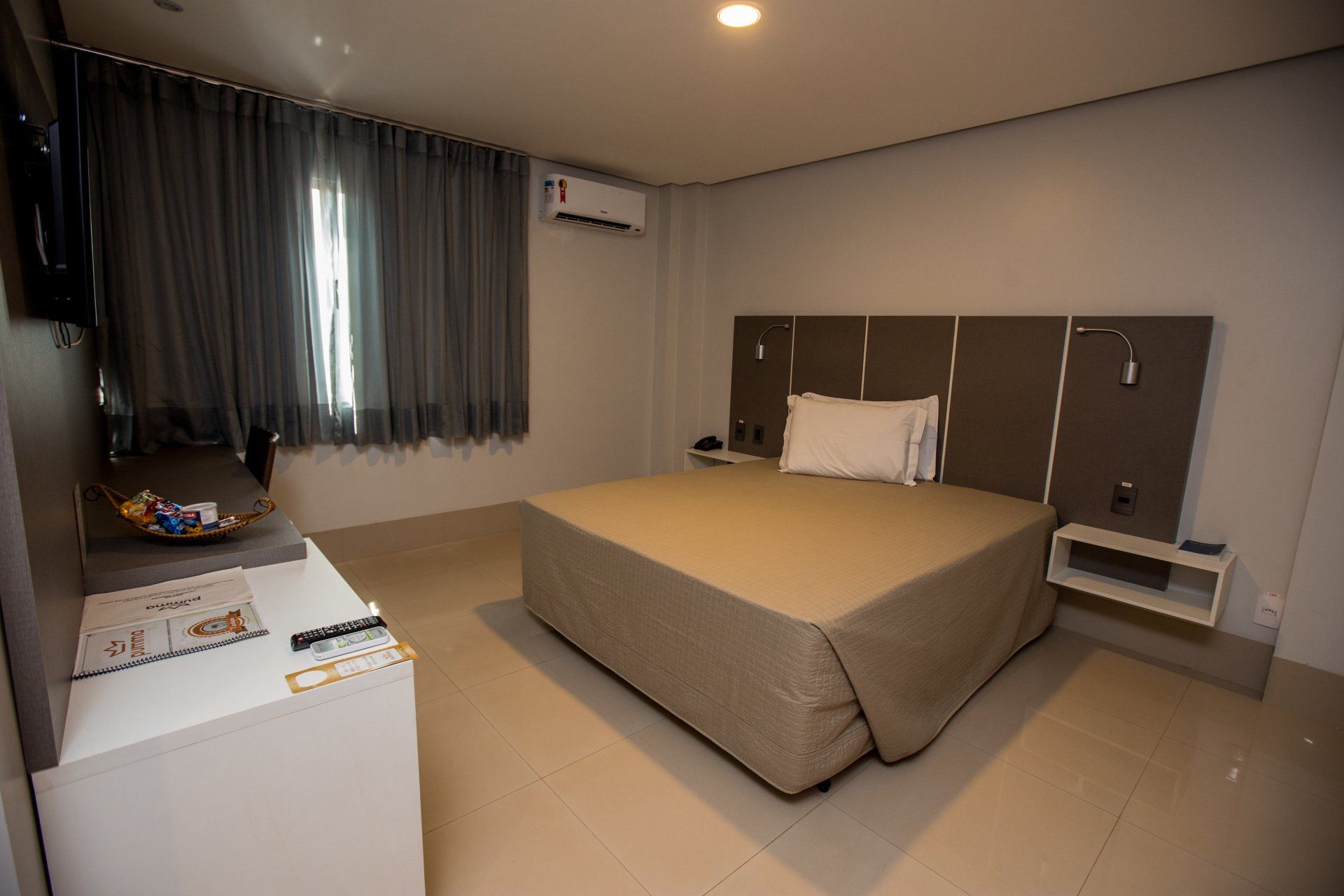 Um quarto de hotel com uma cama king size e uma televisão.