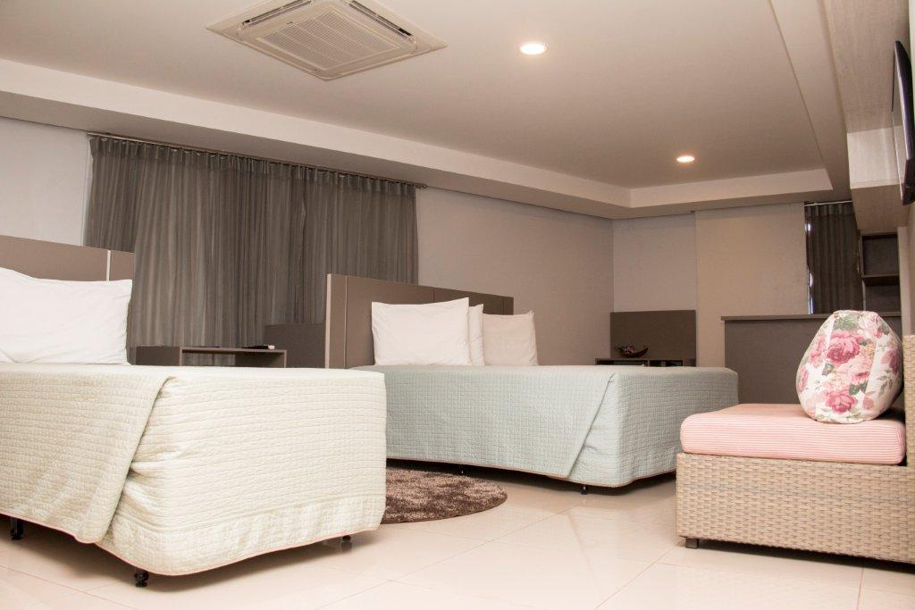 Um quarto de hotel com duas camas e um sofá