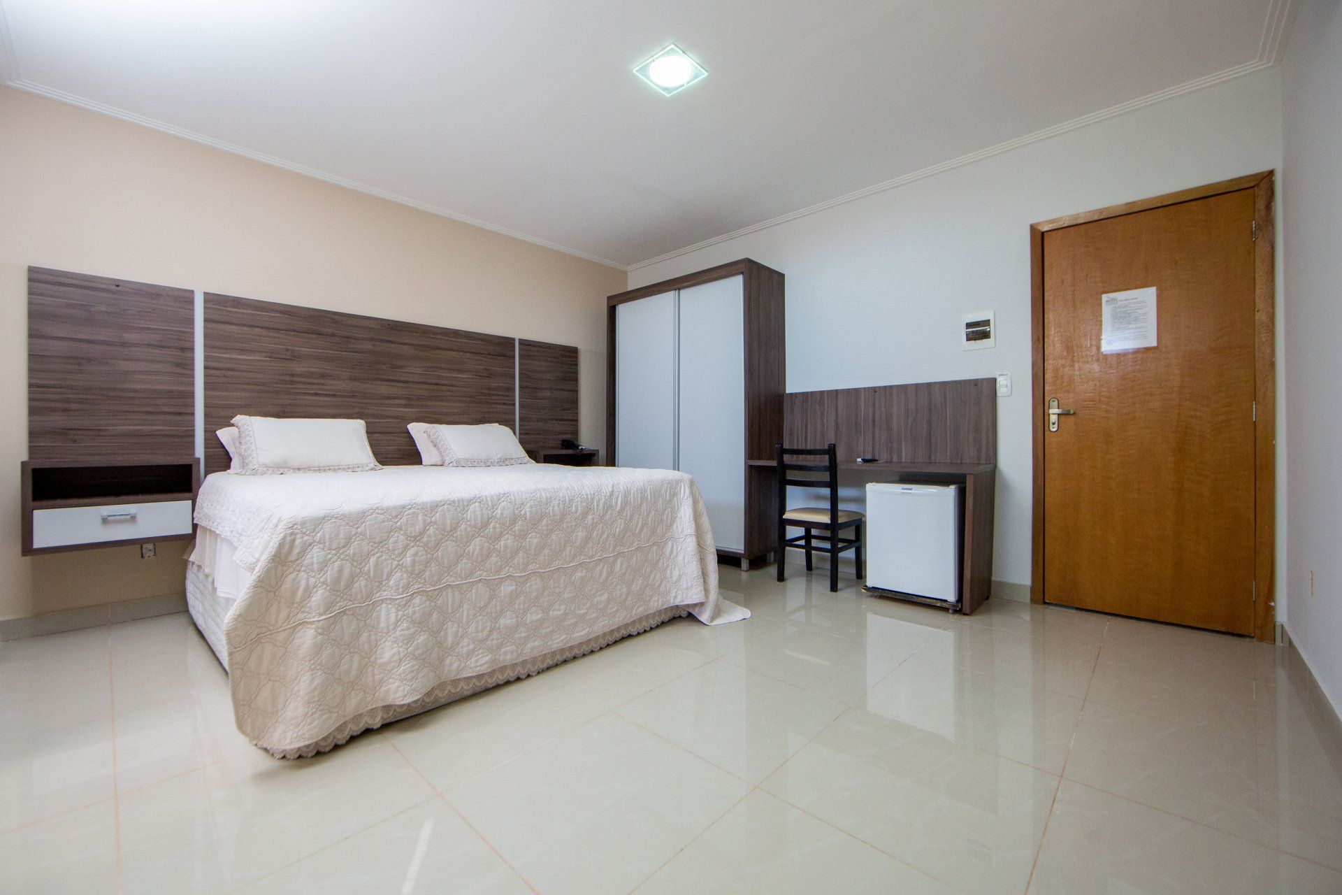 Um quarto de hotel com uma cama king size e uma escrivaninha.