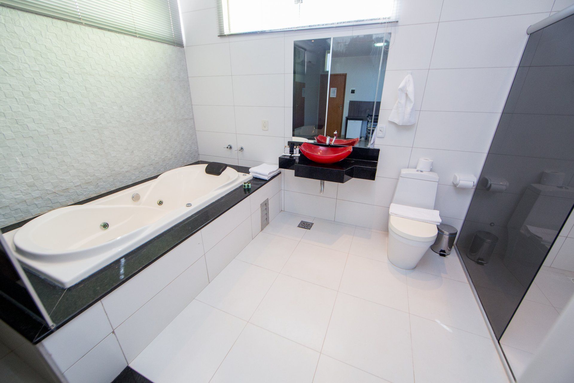 Um banheiro com banheira, vaso sanitário, pia e espelho