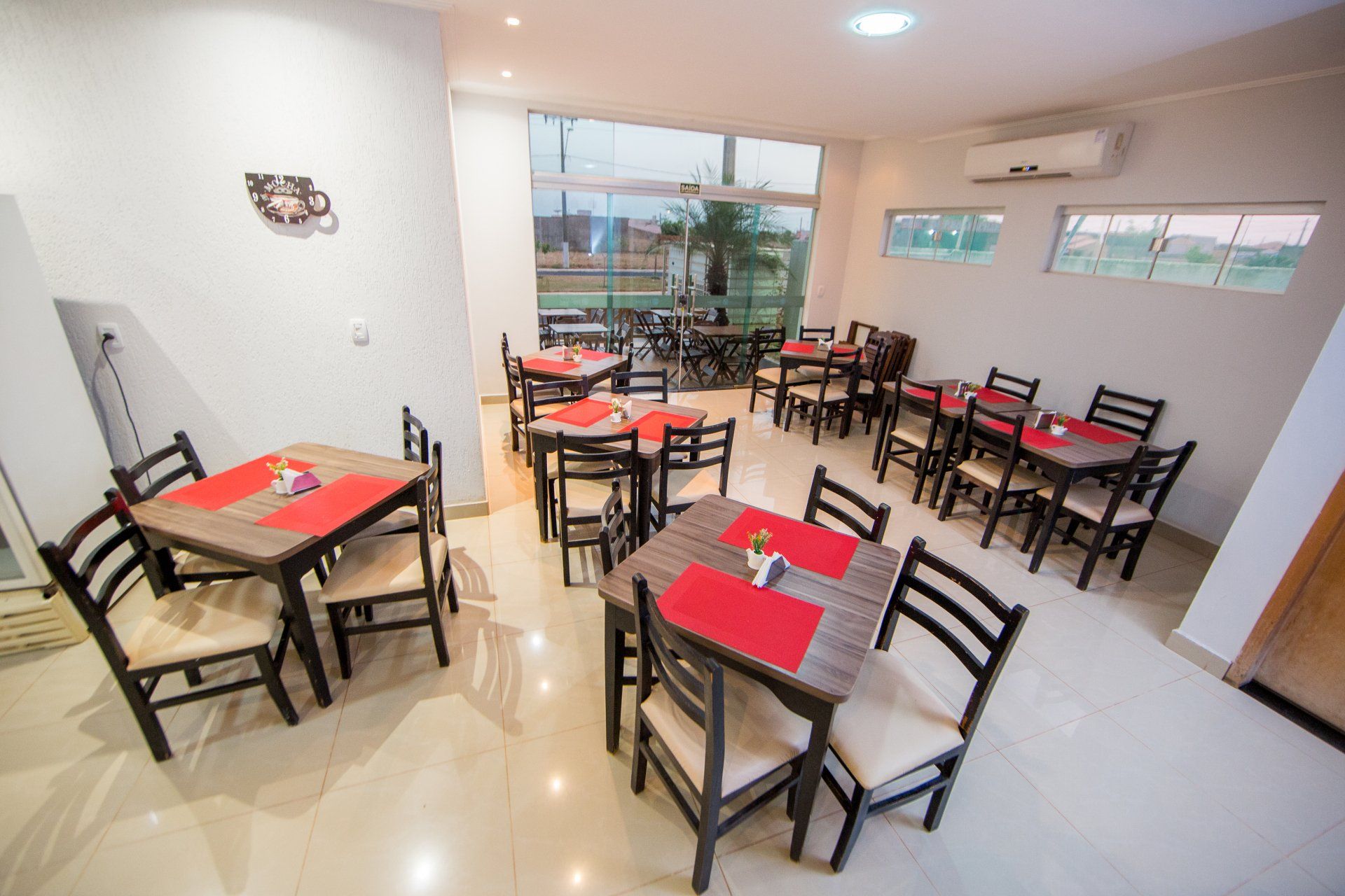 Há muitas mesas e cadeiras na sala.