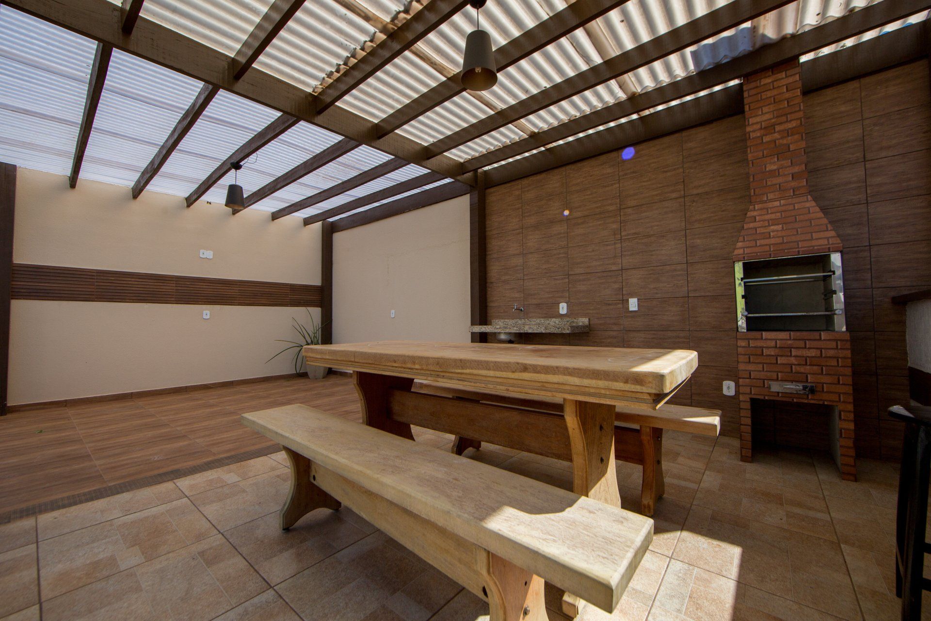 Há uma mesa de madeira e um banco no meio da sala.