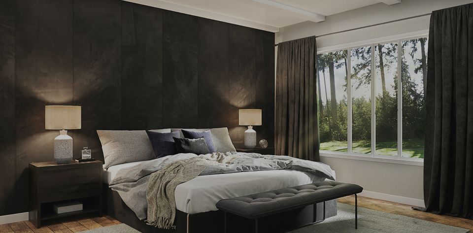 Bedroom with a dark accent wall, bed, and large window overlooking a forest.