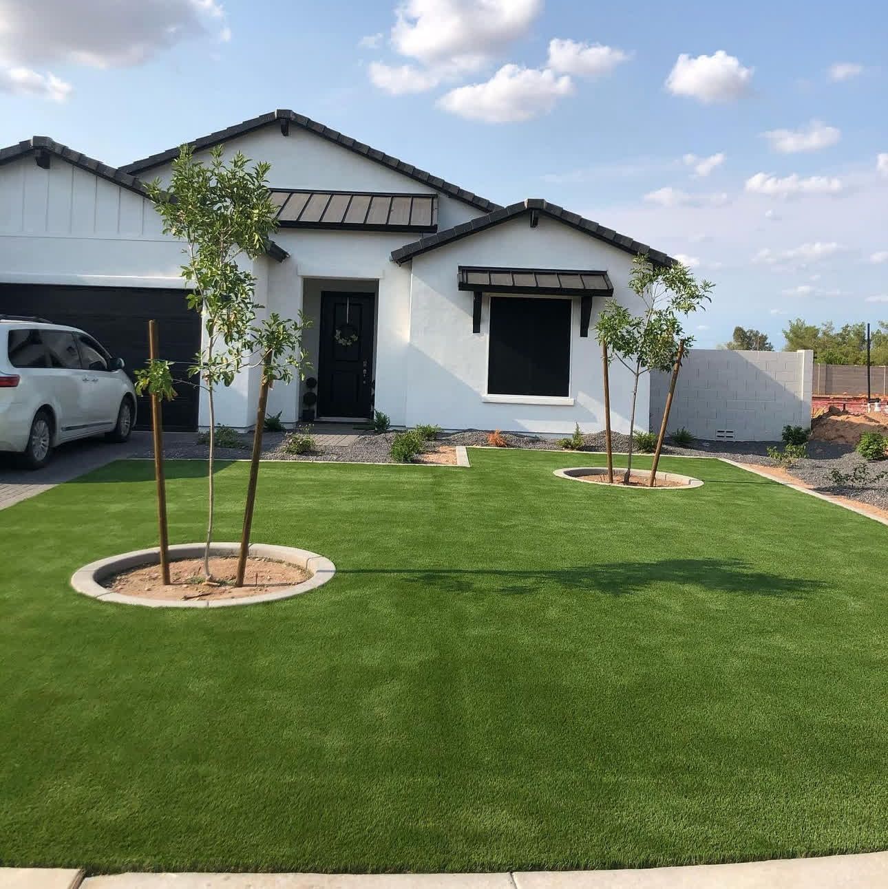 A white house with a car parked in front of it