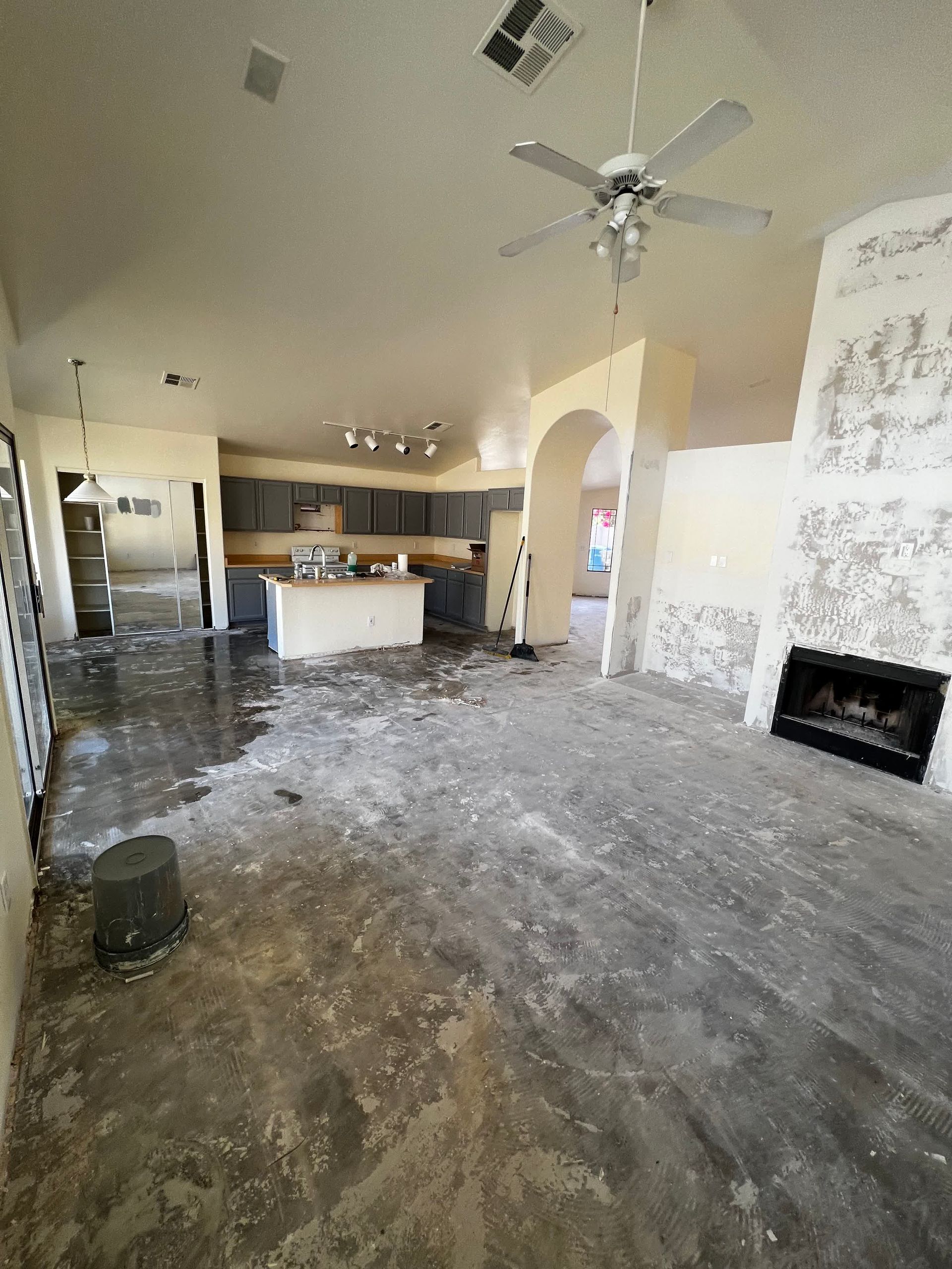 A living room with a ceiling fan and a fireplace.