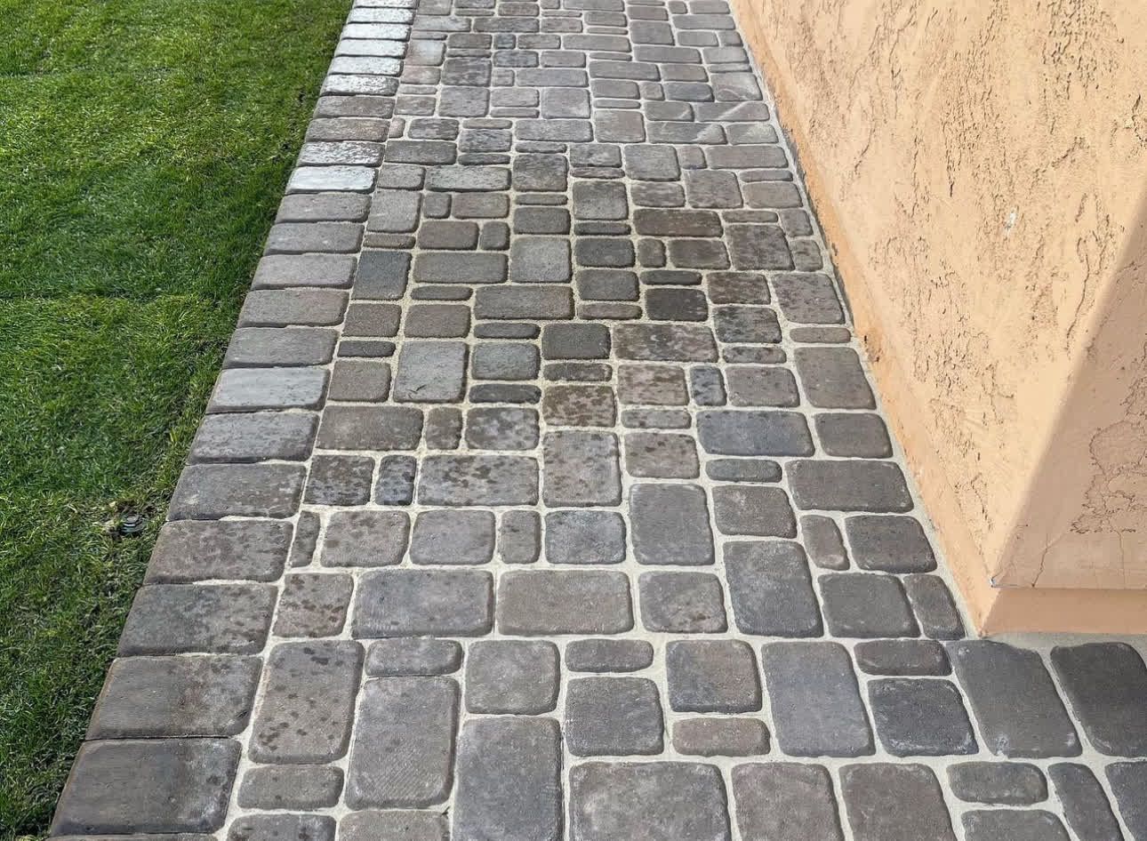 A sidewalk made of bricks next to a building
