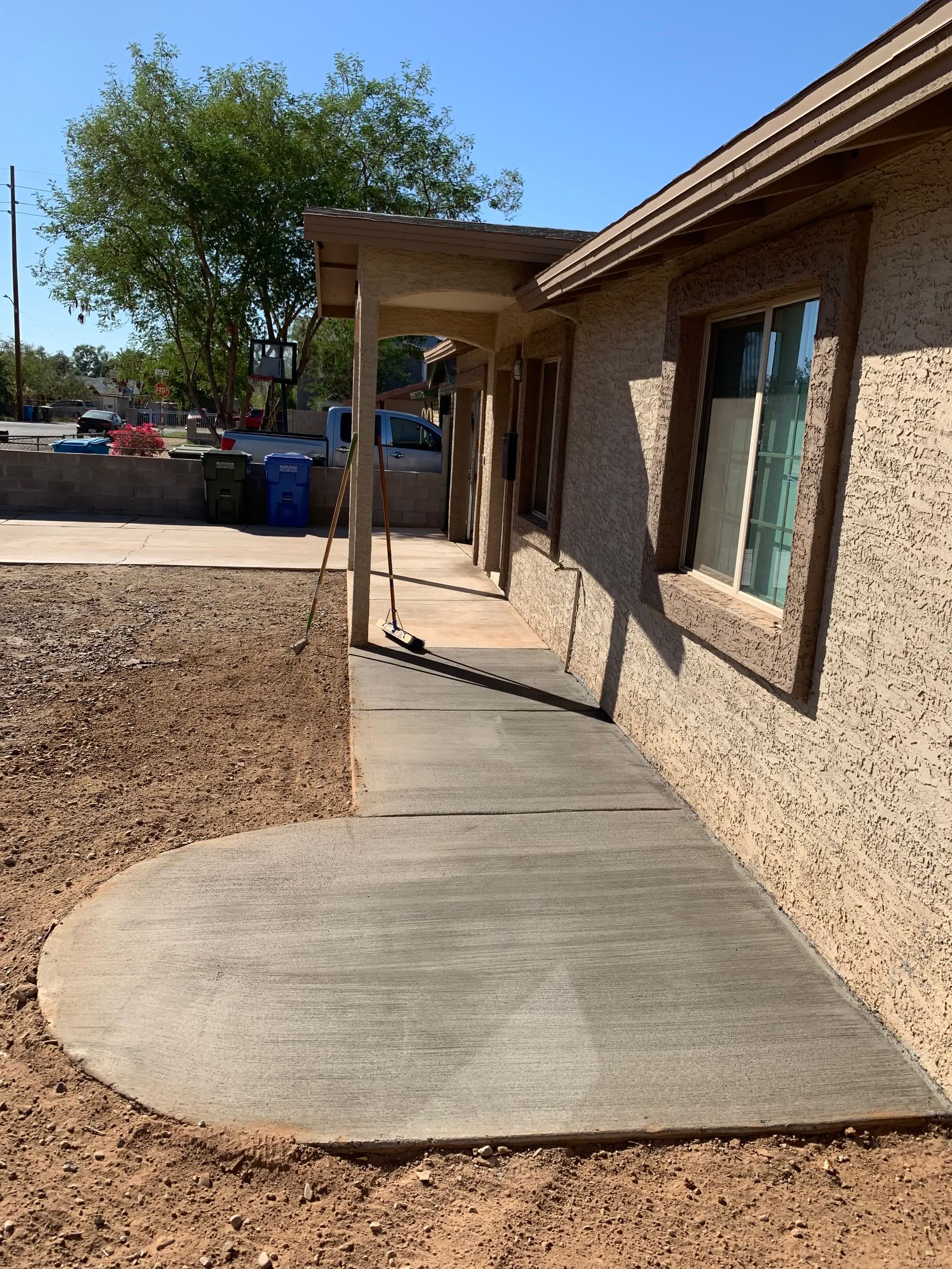 A concrete walkway leading to the front of a house