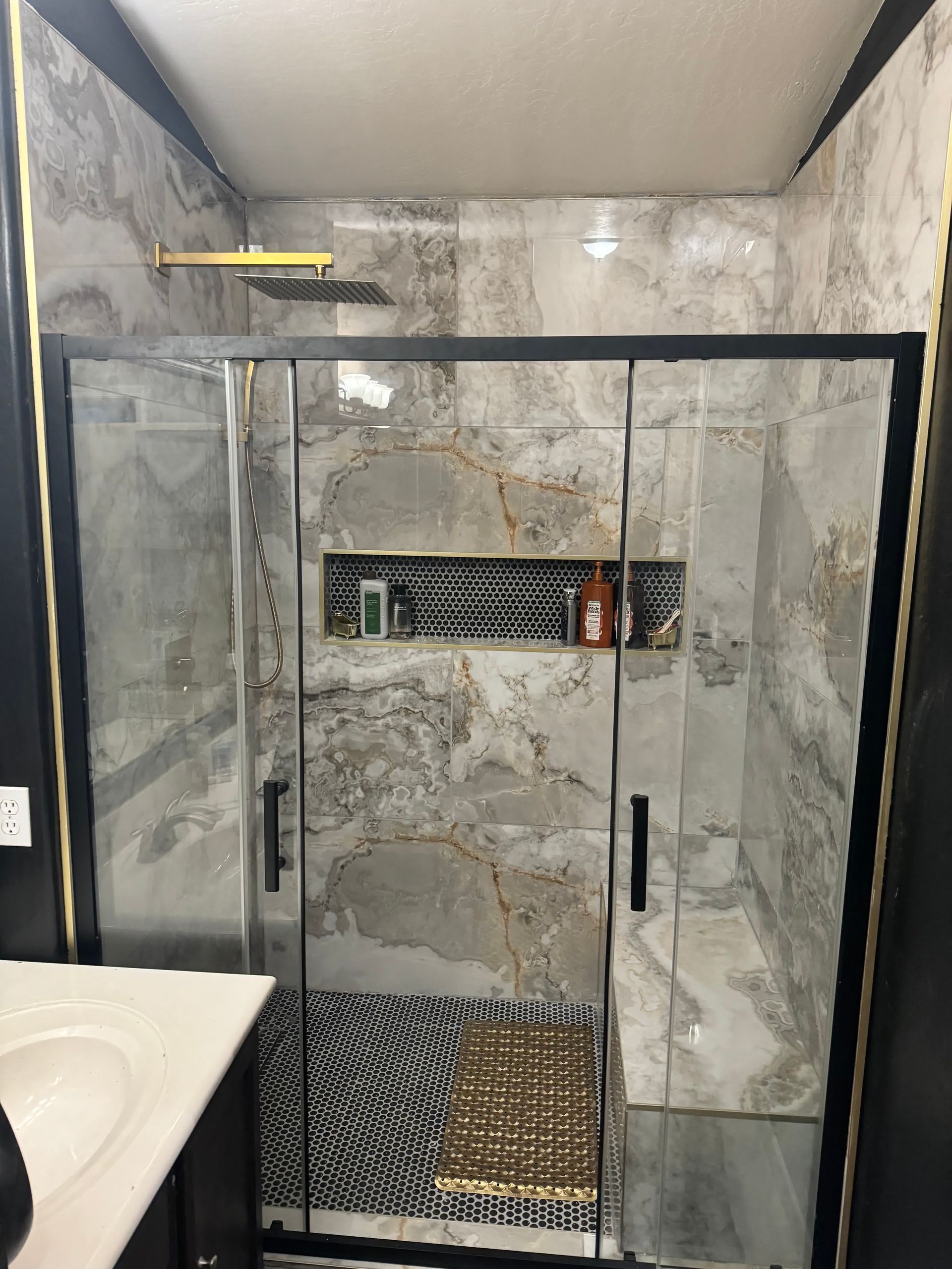 A bathroom with a sliding glass shower door and a sink.