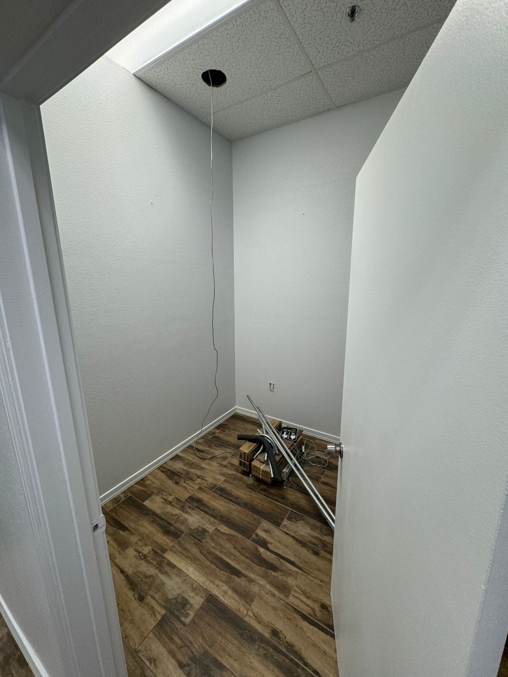 A small room with a wooden floor and white walls.