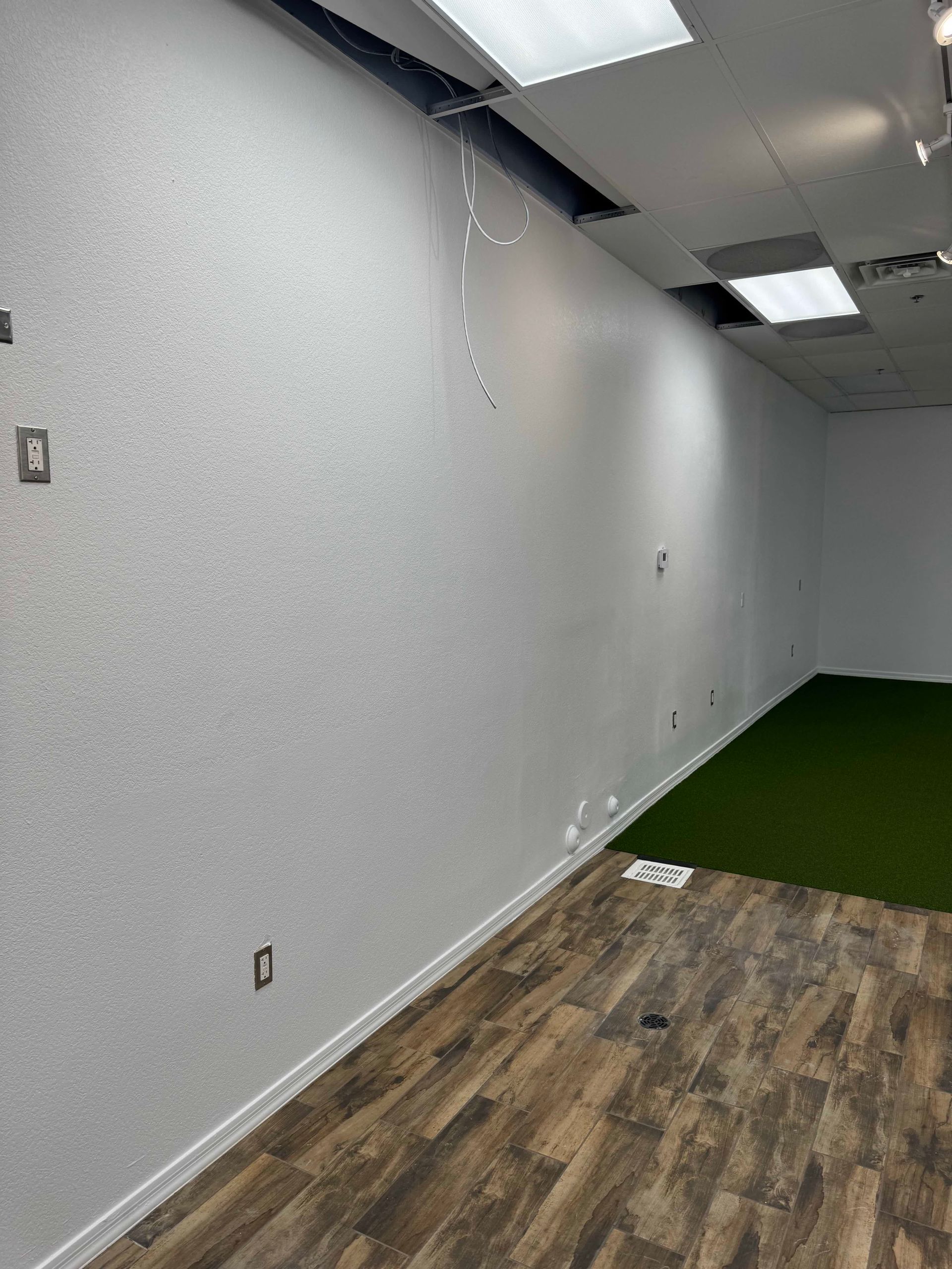 An empty room with white walls and wooden floors.