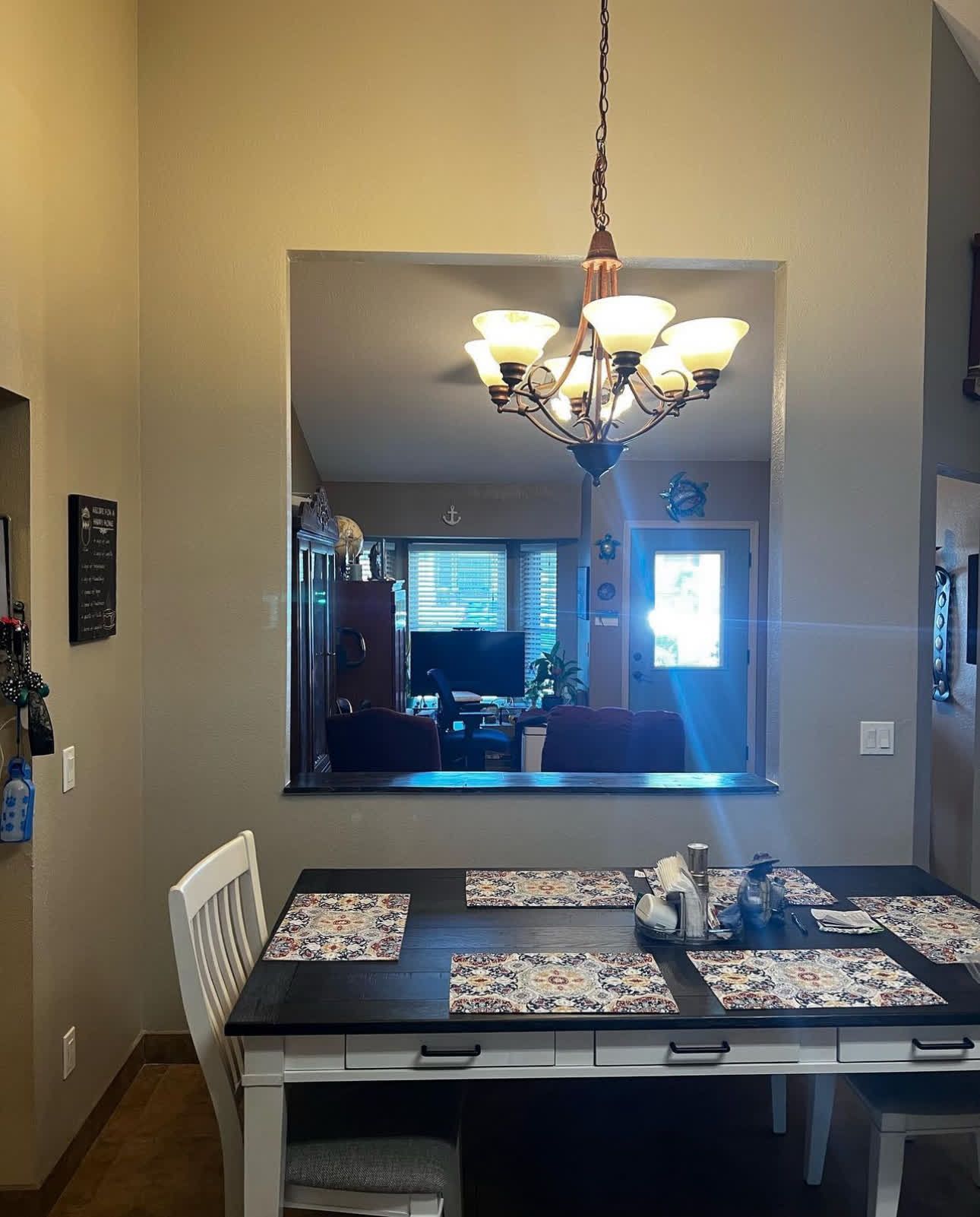 A dining room with a table and chairs and a chandelier