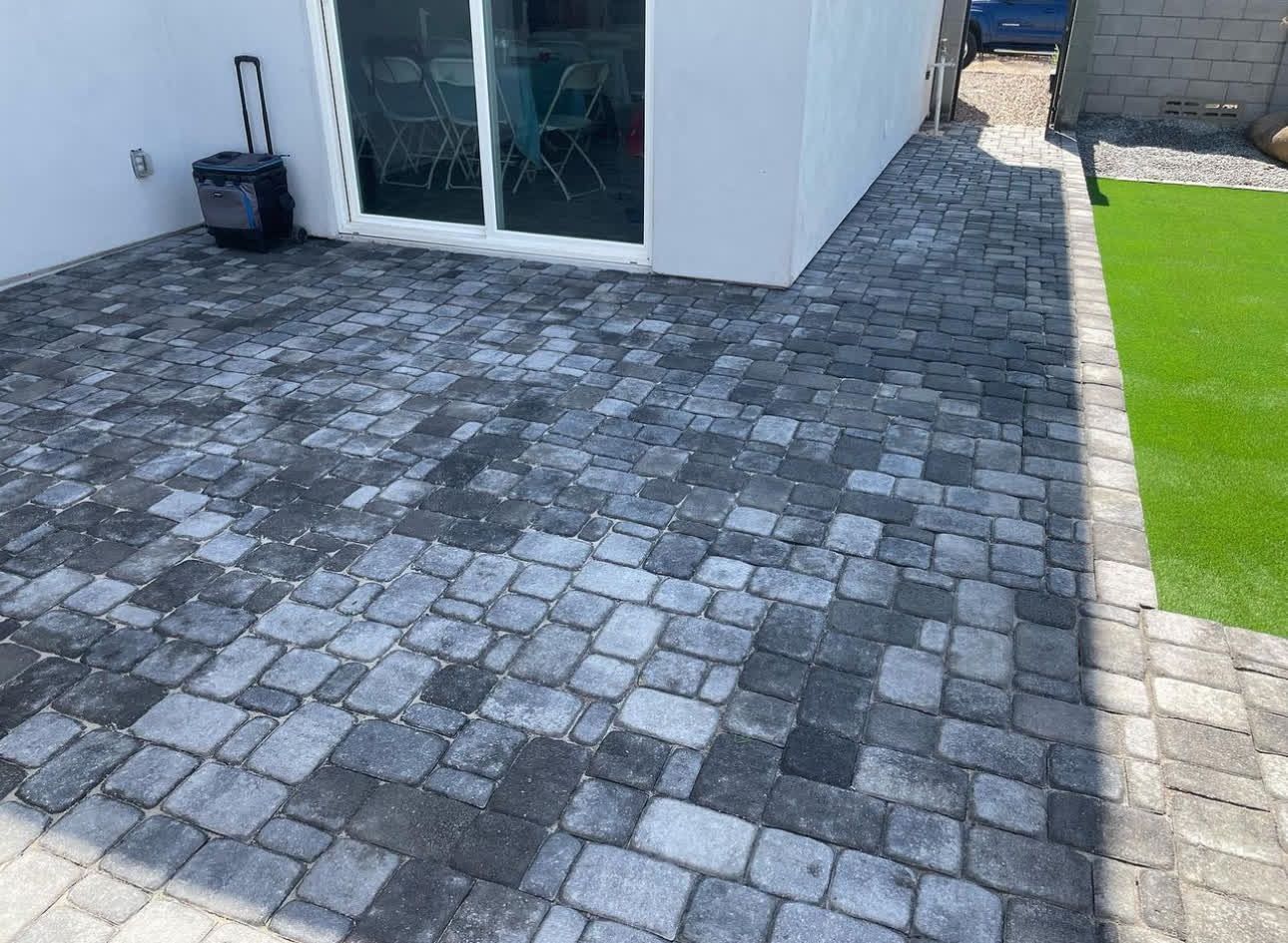 A patio with a sliding glass door next to a house.