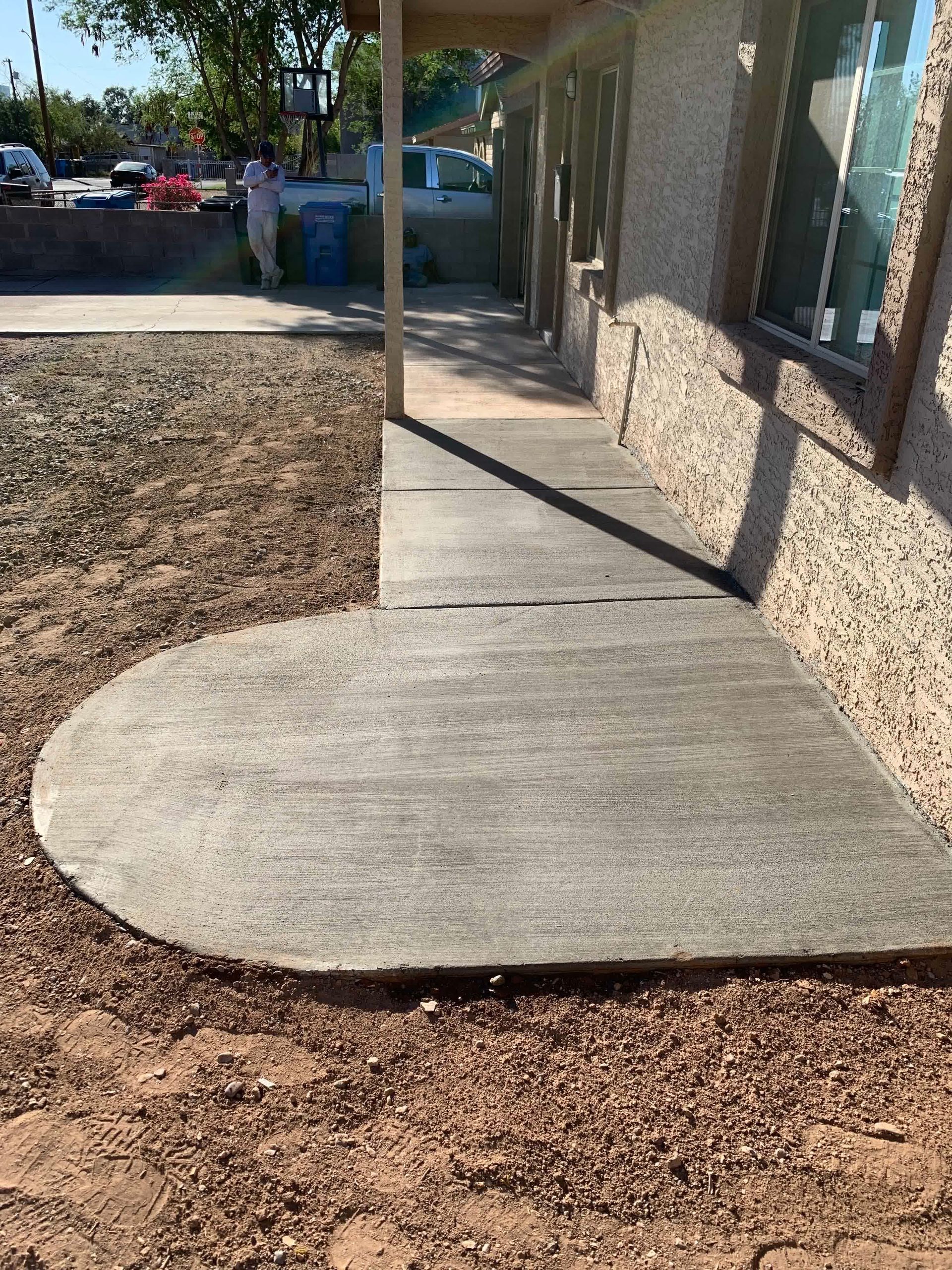 A concrete walkway is being built in front of a building.