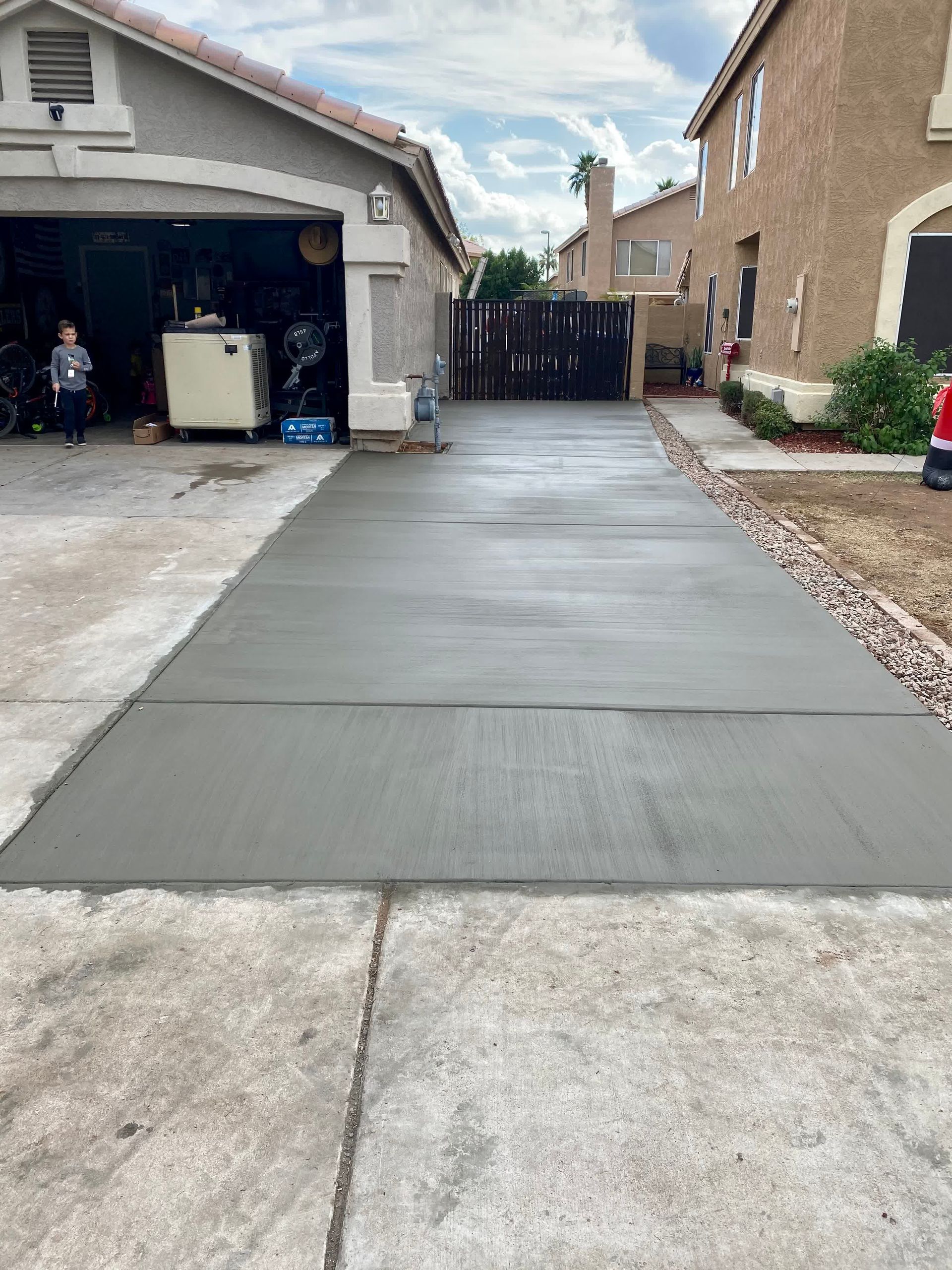 A concrete driveway is being built in front of a house.