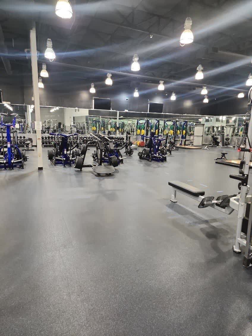 A large gym filled with lots of exercise equipment.