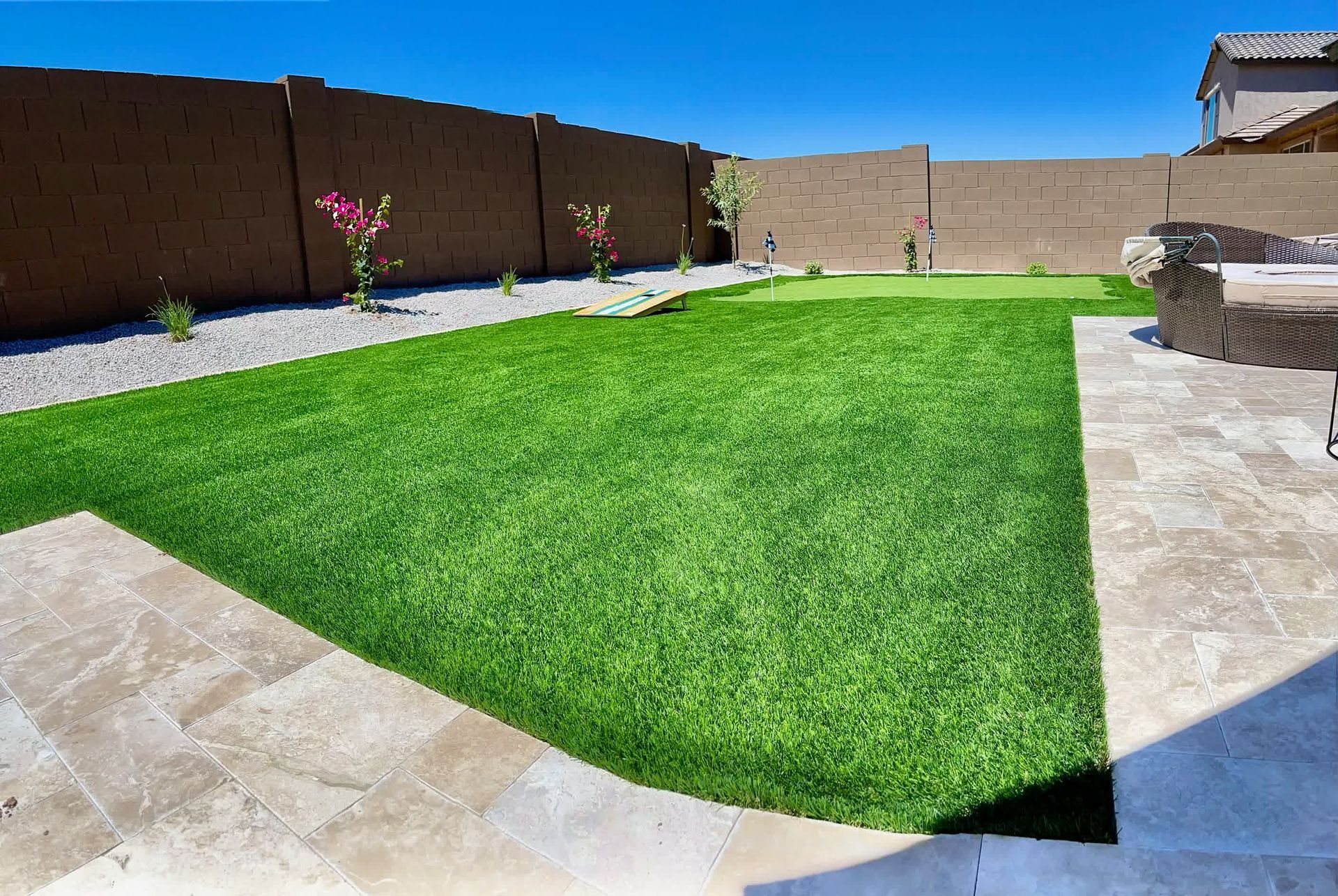 A backyard with a lush green lawn and a patio.