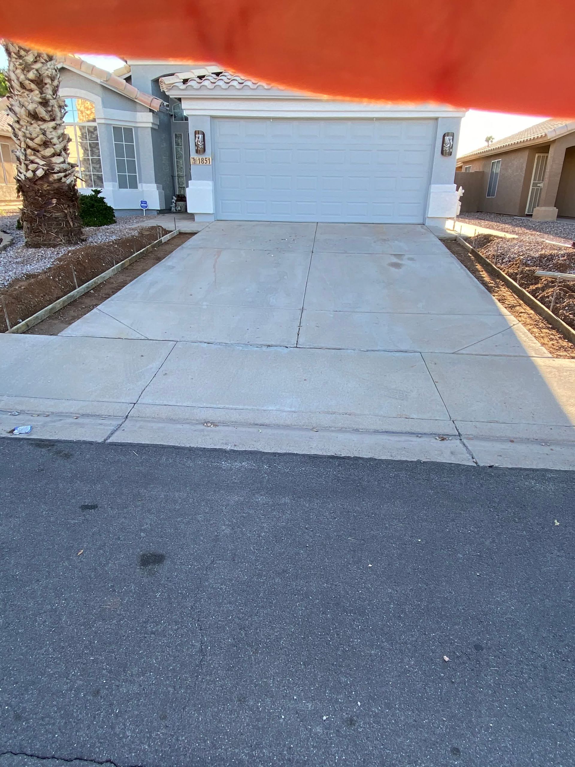 A person is holding a red object in front of a garage door.