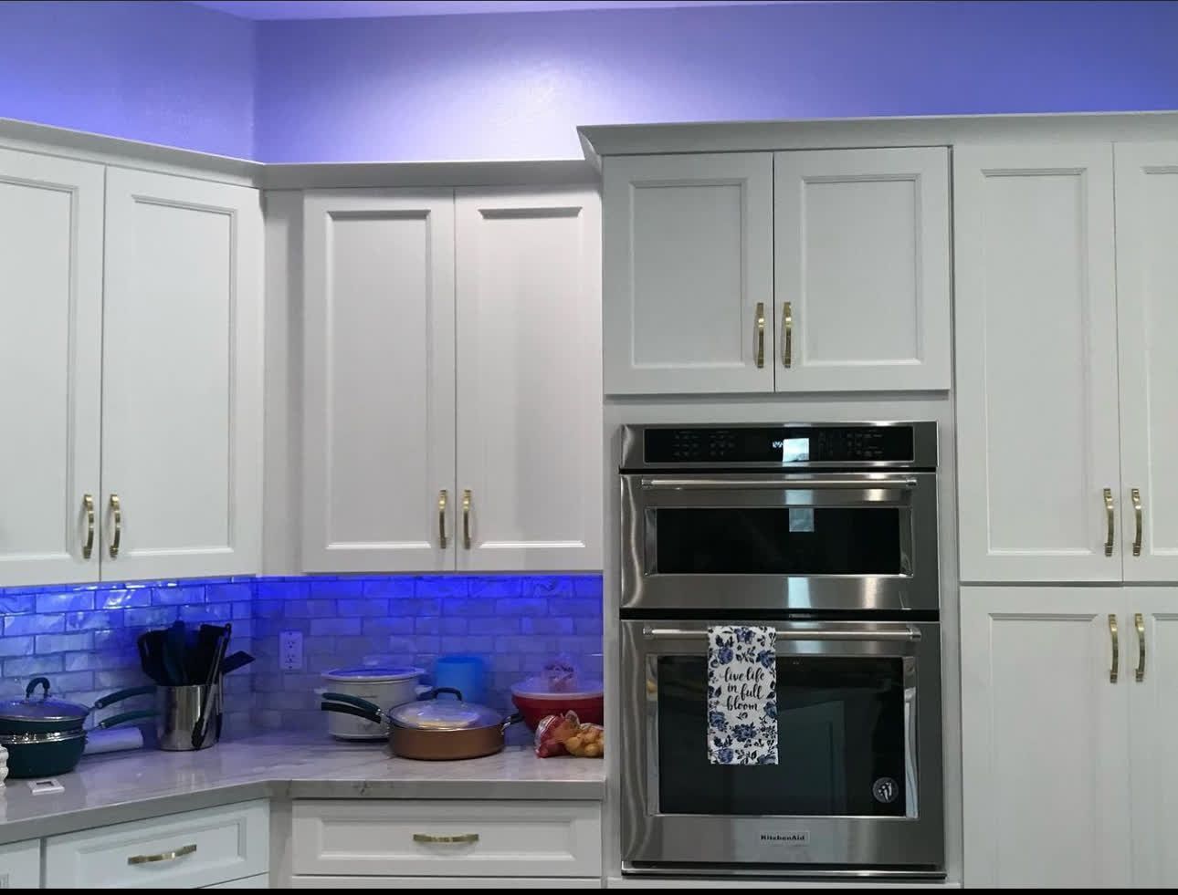 A kitchen with white cabinets and stainless steel appliances