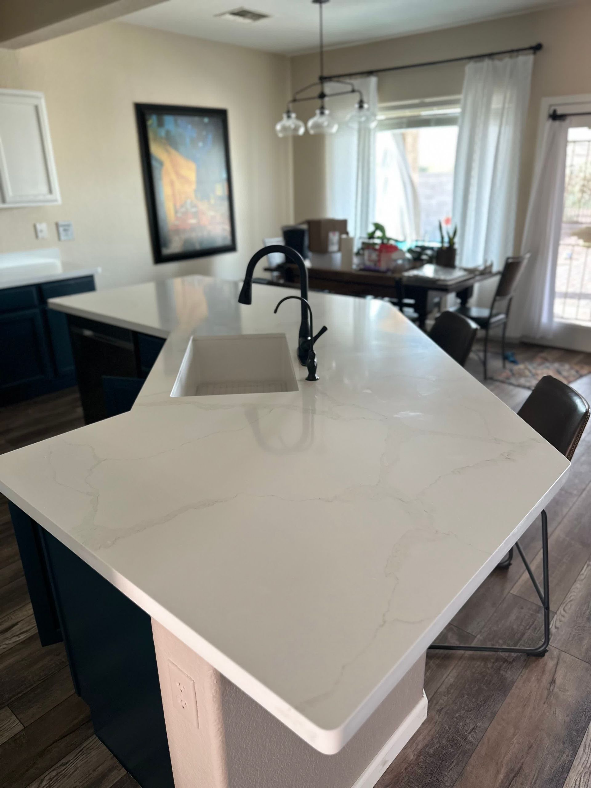 A kitchen with a large white counter top and a sink