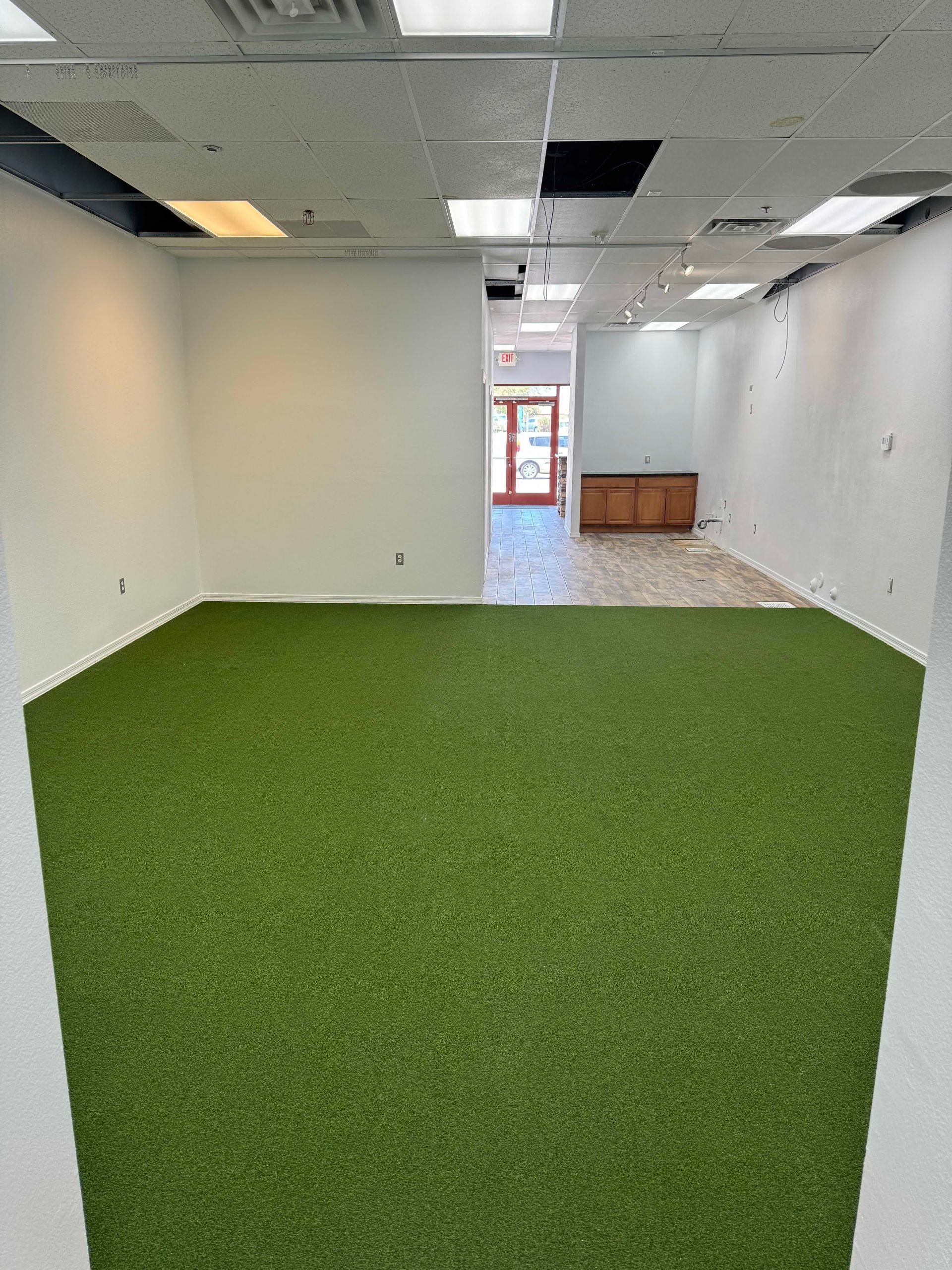 A large room with a lot of green grass on the floor.