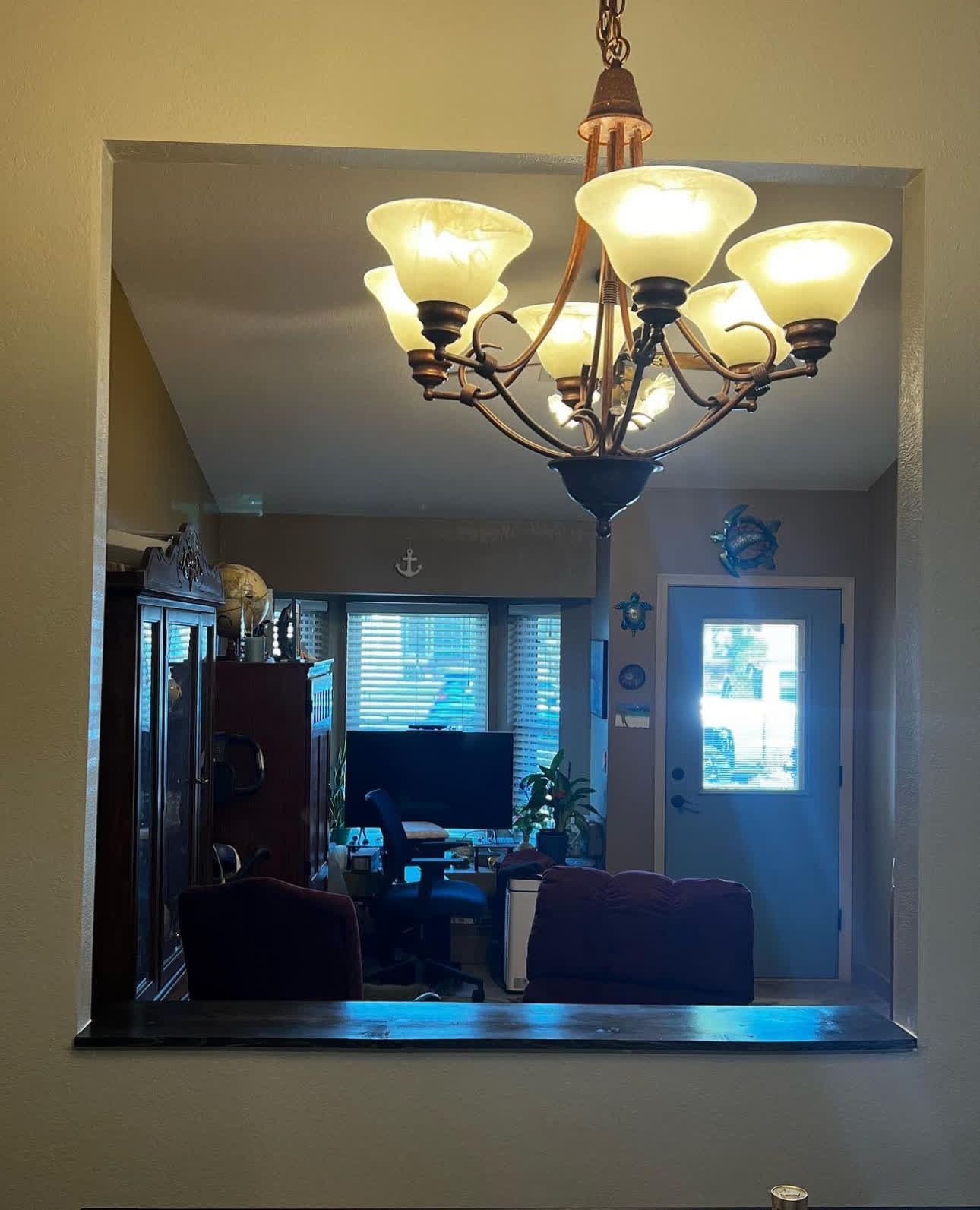 A living room with a chandelier hanging from the ceiling